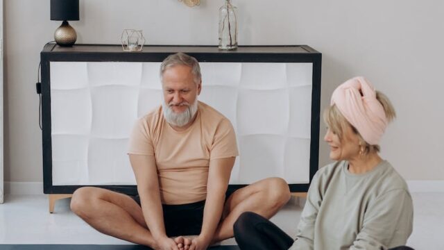 elderly couple exercising together at home