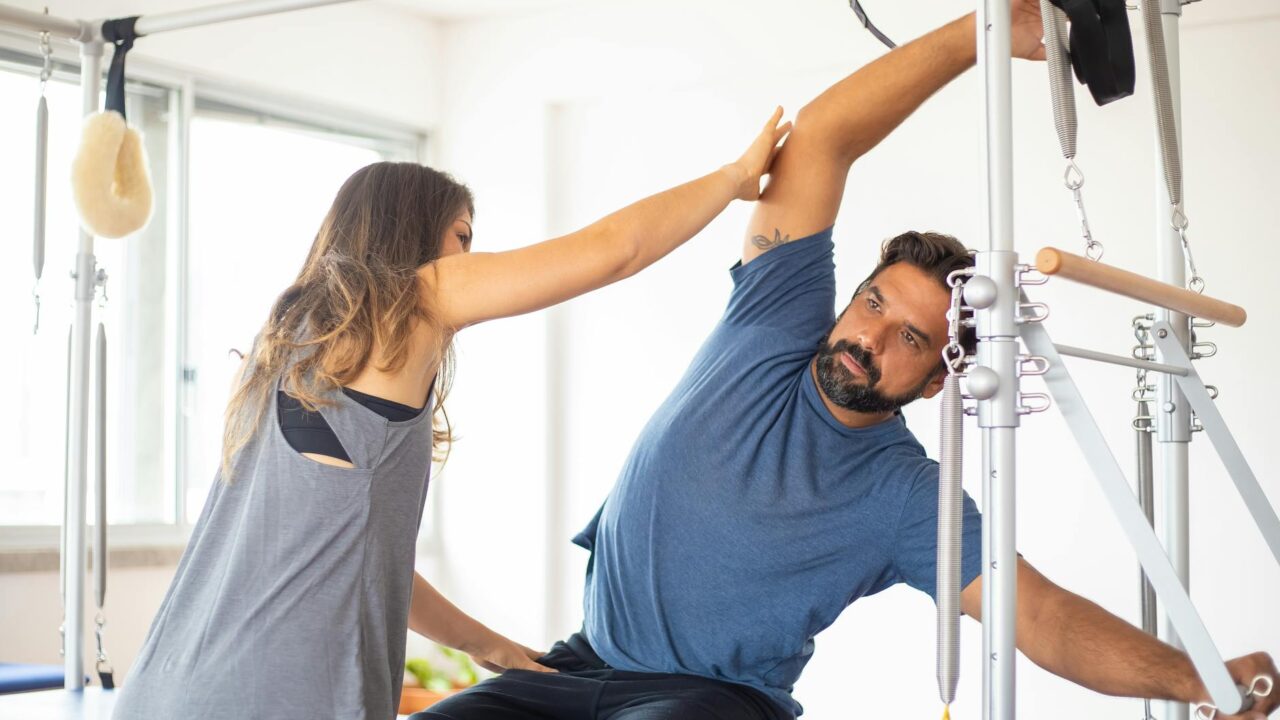 a woman guiding an exercising man